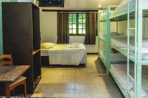 Zimmer mit Etagenbetten, einem Tisch und einem Bett in der Unterkunft Lonier Villa Inn Economic in Abraão