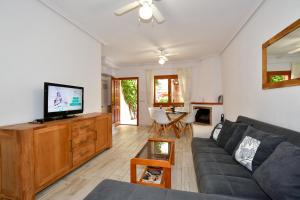 a living room with a couch and a flat screen tv at Apartamento Casa Prima in Playa Flamenca