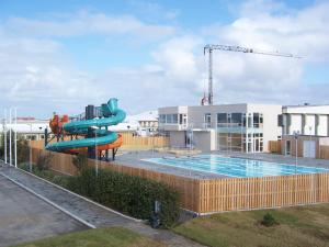 a swimming pool with a water slide in front of a building at iStay Cottages in Sandgerði