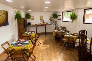 une salle à manger avec des tables, des chaises et un comptoir dans l'établissement Pousada Gente Bonita Geribá, à Búzios