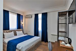 una camera da letto con un grande letto con tende blu di B&B Old Tbilisi a Tbilisi City