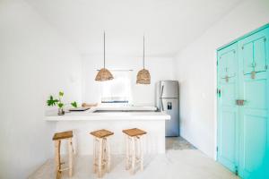 a kitchen with a counter and two stools in it at LunArena Boutique Beach Hotel Yucatan Mexico in El Cuyo