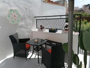 un patio con tavolo e sedie sul balcone. di Casa dei nonni a Capurso