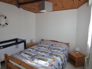 a bedroom with a bed and a clock on the wall at Maison LES SABLES D'OLONNE 700 m Plage WIFI in La Pironnière