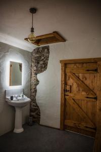 a bathroom with a door and a sink and a mirror at Dans Wee Cottage Slieve Croob Dromara Castlewellan Newcastle in Dromara