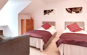 a bedroom with two beds and a couch at Modern Spacious Apartments in Bishops Stortford