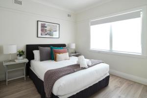 een slaapkamer met een groot bed en een raam bij Garden Apartment - Short Walk to Harbour Bridge in Sydney