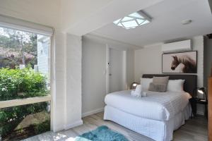 een slaapkamer met een bed met een paardenfoto aan de muur bij Garden Apartment - Short Walk to Harbour Bridge in Sydney
