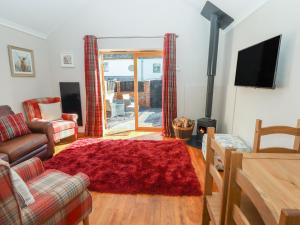 a living room with a couch and a red rug at Top Farm Lodge in Oswestry