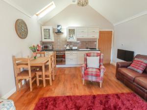 a kitchen and living room with a table and a couch at Top Farm Lodge in Oswestry