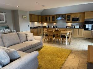 a living room with a couch and a table and a kitchen at Beehive Barn in Berwick-Upon-Tweed