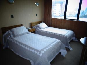 Habitación con 2 camas y ventana en Hotel Antupiren en Puerto Montt