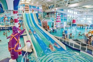 a indoor swimming pool with a water slide at Dianes Private Hire, Hafan Y Mor in Abererch