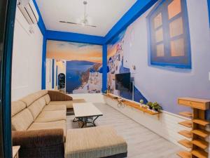 uma sala de estar com um sofá e uma televisão em Sky Tree B&B em Taichung