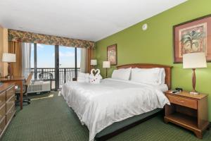 クリアウォーター・ビーチにあるHoliday Inn & Suites Clearwater Beach, an IHG Hotelのベッドとバルコニー付きのホテルルーム