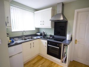 a kitchen with white cabinets and a black stove top oven at The Lodge at Orchard House in Norwich