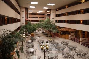 an emptyrium with tables and chairs in a building at Ramada by Wyndham Viscount Suites Tucson East in Tucson