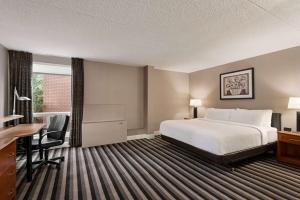 a hotel room with a bed and a desk at Royal Hotel Regina, Trademark Collection by Wyndham in Regina +87 photos