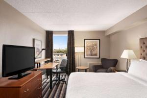 a hotel room with a bed and a flat screen tv at Royal Hotel Regina, Trademark Collection by Wyndham in Regina
