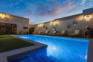 a large swimming pool with chairs and a building at Wyndham Torreon in Torreón