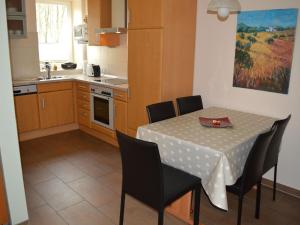 a kitchen with a table with chairs and a tablecloth on it at Holiday home in Lindern with garden in Werlte