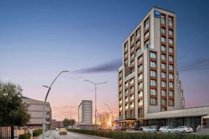 a tall building on a city street with cars parked at Tryp by Wyndham Istanbul Topkapi in Istanbul