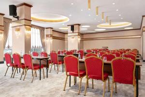 a conference room with a long table and red chairs at Tryp by Wyndham Istanbul Topkapi in Istanbul