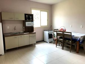 uma pequena cozinha com uma mesa e um micro-ondas em Casa no Vale dos Vinhedos em Bento Gonçalves