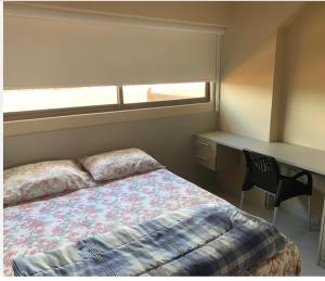 - une chambre avec un lit, un bureau et une fenêtre dans l'établissement Cupe Beach Living Porto de Galinhas, à Porto de Galinhas