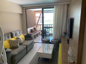 - un salon avec un canapé et une table dans l'établissement Cupe Beach Living Porto de Galinhas, à Porto de Galinhas