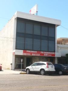 um edifício com um carro estacionado em frente em Premier Hotel Suites em Ciudad Obregón