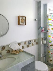 a bathroom with a sink and a toilet and a mirror at Casa Pontal dos Carneiros - Praia dos Carneiros in Recife +19 photos