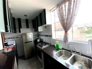 una pequeña cocina con fregadero y ventana en Dep BONITO Y COMODO EN SURCO, en Lima