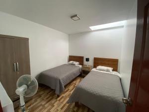 Habitación con 2 camas y ventilador. en Dep BONITO Y COMODO EN SURCO, en Lima