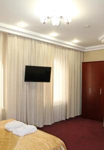 a hotel room with a bed and a flat screen tv at Afalina Hotel in Khabarovsk