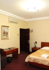 a hotel room with a bedroom with a bed and a desk at Afalina Hotel in Khabarovsk