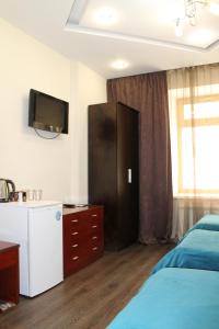 ハバロフスクにあるAfalina Hotelのベッドルーム1室(ベッド1台、壁掛けテレビ付)
