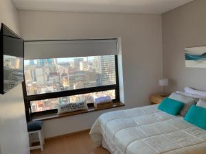ブエノスアイレスにあるBuenos Aires View - Apart 2 Amb sobre Av Corrientesのベッドルーム1室(ベッド1台、大きな窓付)