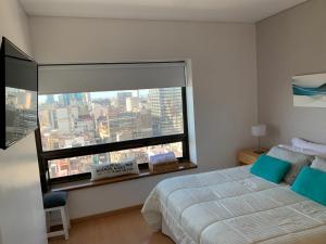 ブエノスアイレスにあるBuenos Aires View - Apart 2 Amb sobre Av Corrientesのベッドと大きな窓のある寝室