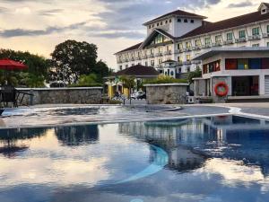 un hotel con piscina frente a un edificio en Klana Beach Resort Port Dickson, en Port Dickson