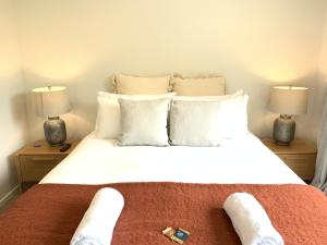een slaapkamer met een groot wit bed met 2 lampen bij Hillside Studio in Queenstown