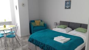sypialnia z łóżkiem, stołem i krzesłem w obiekcie Apartament z panoramicznym widokiem na morze blisko plaży i centrum PL ENG DE w mieście Międzyzdroje