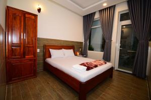 a bedroom with a bed and a cabinet and windows at Nhà nghỉ Hùng Hoa in Phan Thiet +45 photos