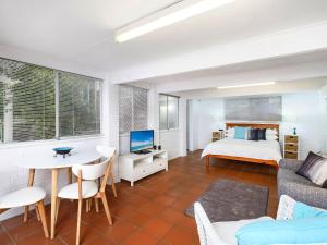 a bedroom with a bed and a table and a couch at Comfy Studio with Idyllic Yard in Great Location in Terrigal