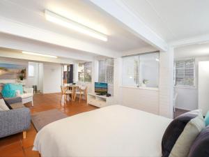 a bedroom with a bed and a living room at Comfy Studio with Idyllic Yard in Great Location in Terrigal
