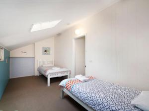 a bedroom with two beds and a skylight at Family Beachside Getaway with BBQ and Patio in Terrigal