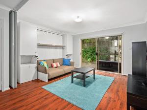 a living room with a couch and a table at Spacious House with Balcony & Pool, Walks to Beach in Terrigal
