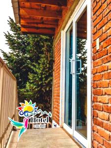 a door to a house with a sign on it at HOTEL COLIBRÍ in Creel