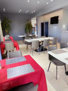 Oxley Motor Inn في بريزبين: مطعم بالطاولات والكراسي مع طاولة قماش حمراء