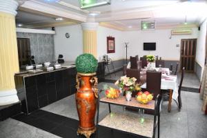 ein großes Zimmer mit einem Tisch mit grünem Hut darauf in der Unterkunft Room in Lodge - Choice Gate Hotel SuitesPresidential Suite for 6 in Benin-Stadt